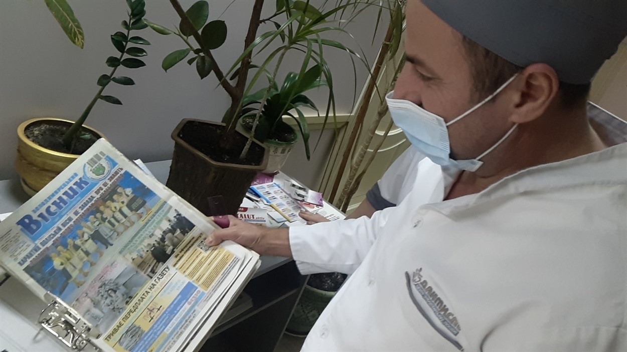 Анатолій Павлович не позує. Він демонструє підшивки газет, які цікаві колективу.