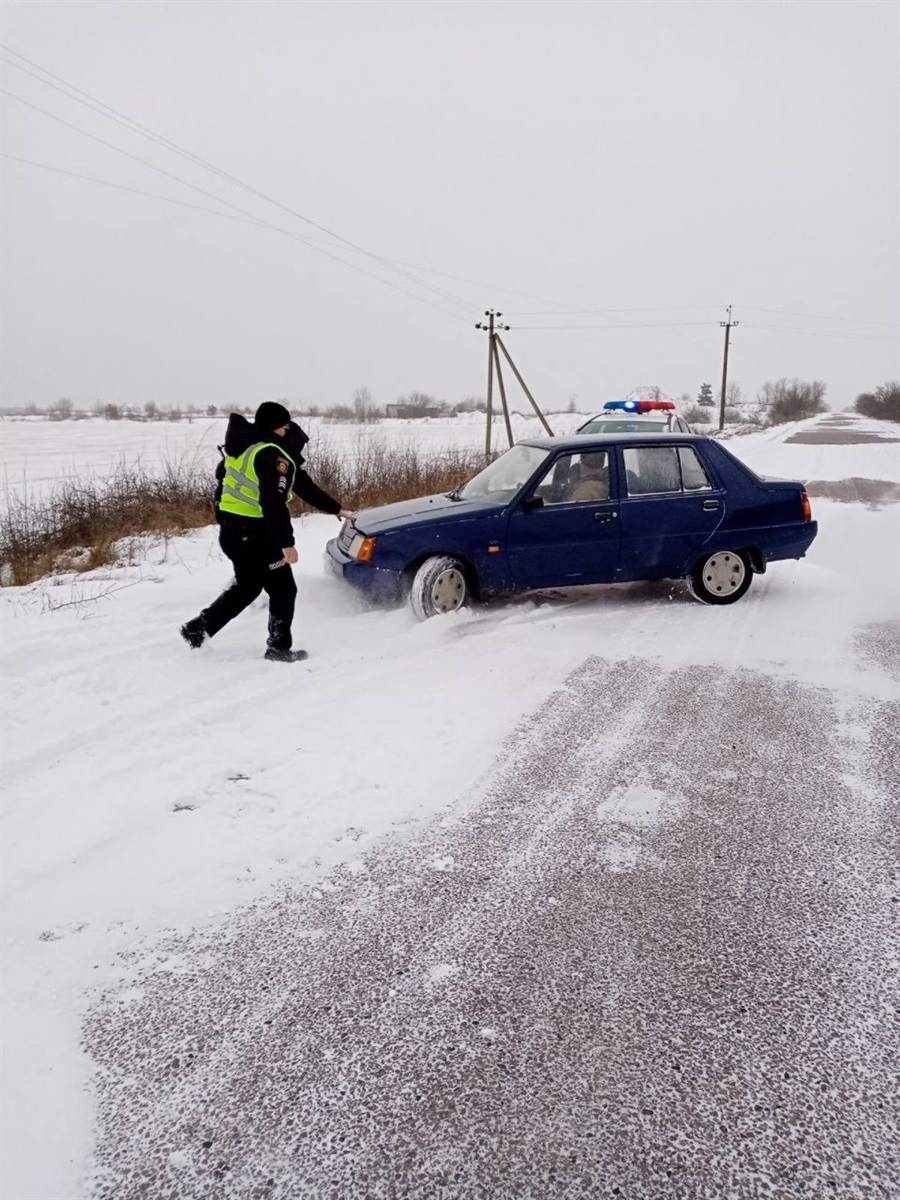 Руслан Дяк, Юрій Стібиш з сектору реагування патрульної поліції допомагають виїхати авто